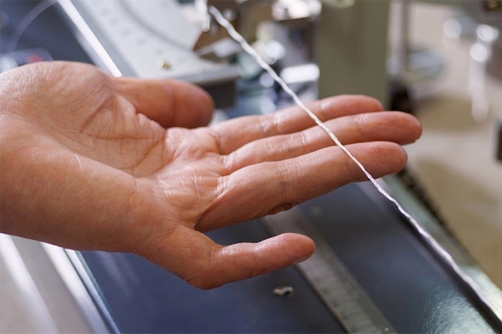 SQG laboratory performing tensile strength test on high-performance safety glove fiber.