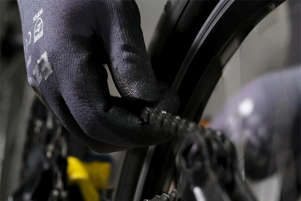 Macro view of SQG EZGRIP micro-finish nitrile coating providing secure vacuum grip on an oily metal surface.